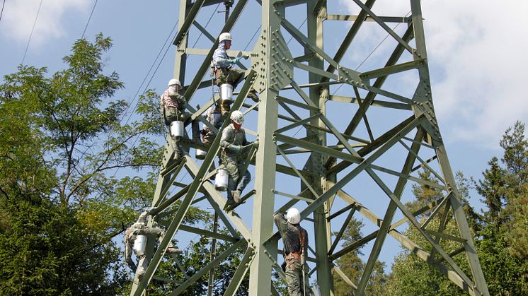 Mit dem Farbeimer am Gürtel klettern die Techniker auf die Masten und geben ihnen einen frischen Anstrich.