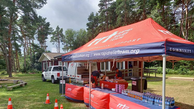 Volontärer från Rapid Relief Team förbereder mat och dryck till barnen på sommarkollo