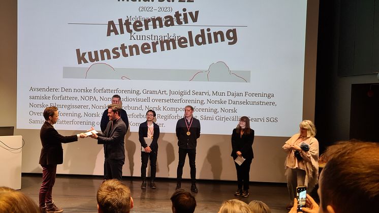 "Alternativ Kunstnermelding" ble lagt frem av kunstnerne på Kunstnernes Hus. Leder av Stortingets familie- og kulturkomité, Grunde Almeland, mottok det første eksemplaret på vegne av politikerne. Foto: Beate Styri