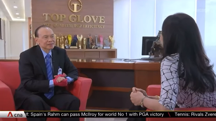 Dr Lim Wee Chai gives an interview with his product shown prominently on his right hand