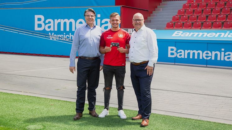 Jochen A. Rotthaus, Bayer04 Leverkusen (l.) und Heiko Scholz, Barmenia (r.) mit dem Botschafter von Bayer04 Marvin "M4RV" Hintz