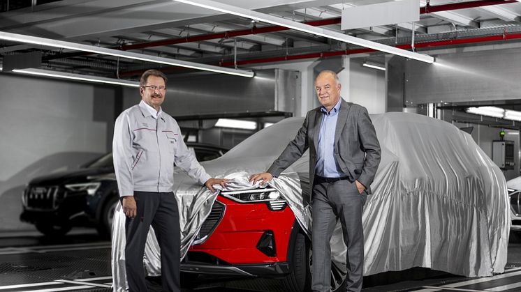Patrick Danau, chef för Audi Bryssel och Peter Kössler, produktions- och logistikchef AUDI AG lyfter på täcket till nya Audi e-tron