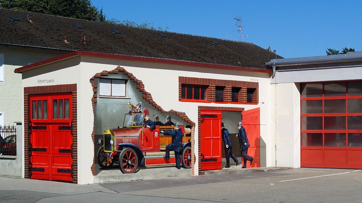 Kunst am Trafo: Historisches Löschfahrzeug am Feuerwehrhaus in Neuötting