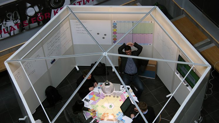 De fyra studenterna i intensivt arbete runt "spelplanen" som tar dem framåt i innovationsprocessen.