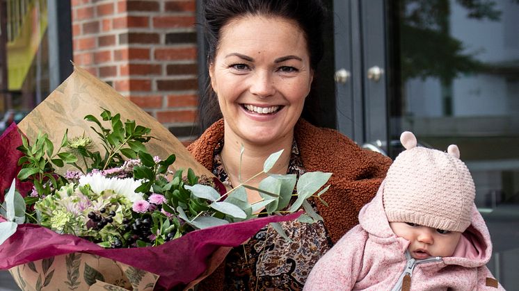 Lina Alvenius, ordförande i HK Eskil, tar tillsammans med dottern emot blommor och diplom.