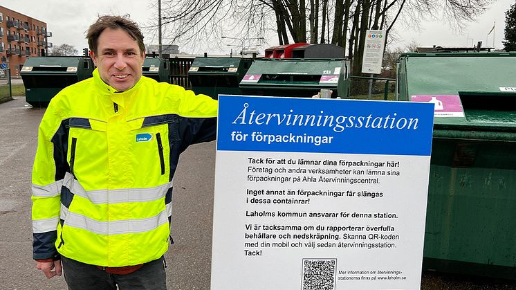 Daniel Zetreus, avfallsplanerare i Laholm, vid återvinningsstation med ny informationsskylt.
