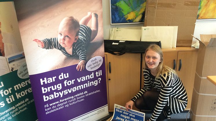 Kontorelev Janni Karlsen er i fuld sving med at pakke plakater og bannere som i den kom-mende tid skal reklamere for den nye portal. Foto: Rebild Kommune