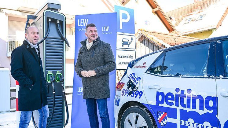 Laden mit einer Leistung bis zu 150 KW – Peitings Erster Bürgermeister, Peter Ostenrieder, und Andreas Bayer, Kommunalbetreuer der Lechwerke (LEW), freuen sich über den neuen DC-Lader im Stadtzentrum. (Bildnachweis: LEW / Thorsten Franzisi) 