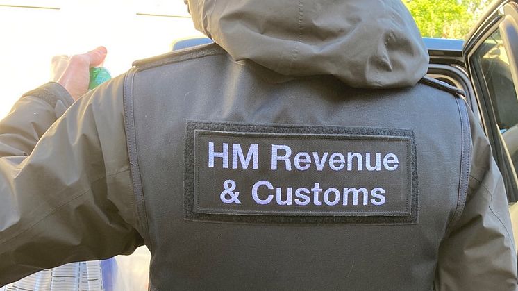 An HMRC officer seizes evidence, following a coordinated operation across England into large-scale tax repayment fraud
