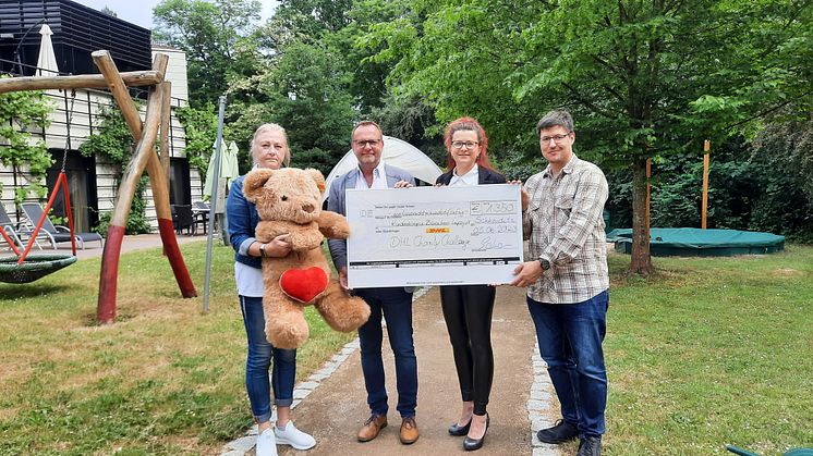 Elvira Wegner (Bärenherz) nimmt den Spendenerlös der Christmas Charity Challenge 2022 von Marco Rößner, Nicole Stepponat und Thomas Marx vom DHL Hub Leipzig entgegen.