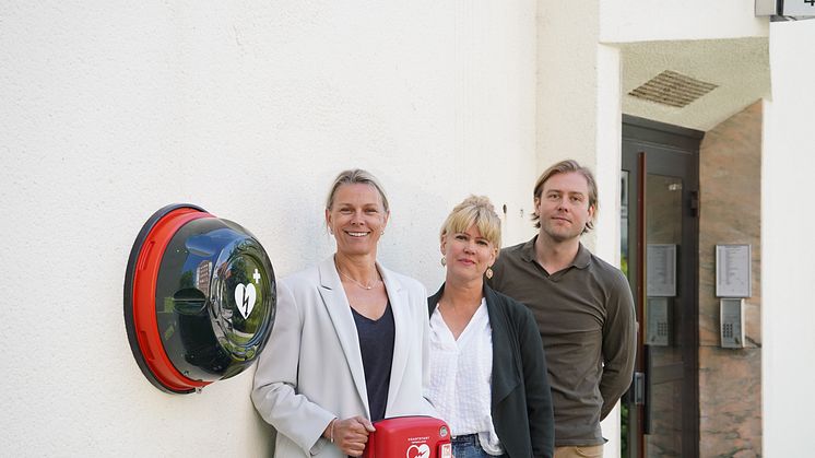 Hjärtstartare på fasaden i Solna. Från vänster Anna-Carin Strandberg, VD på Philips Sverige, Linda Myron, Insamlingschef på Hjärt-Lungfonden och Johan Westin, försäljningschef på AIK Fotboll.