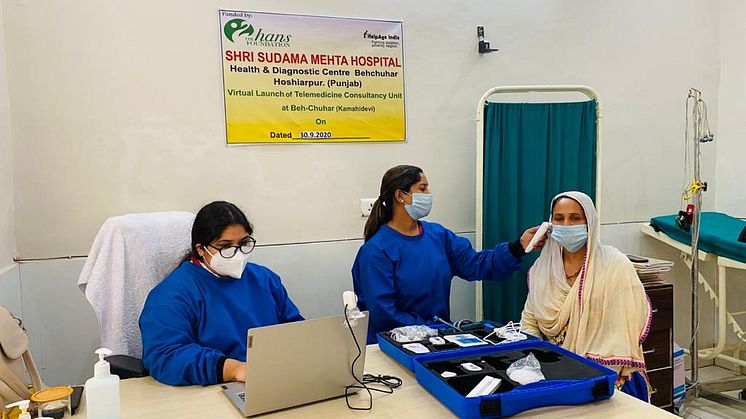 En allmänläkare bistår i telekonsultation mellan specialistläkare och patient. En sjuksköterska tar tempen med hjälp av ett telemedicin kit. Bilden är tagen på Shri Sudama Mehta-sjukhuset i byn Beh Chuhar i Punjab.