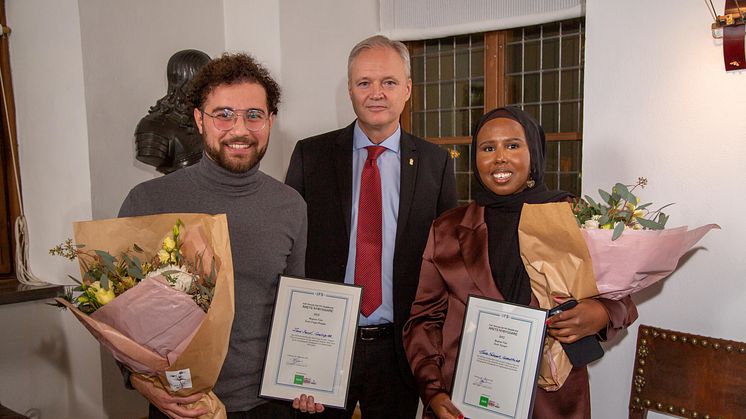 Zaid Saeed och Hinda Mohamud tar emot pris av landshövding Sten Tolgfors. De har tillsammans med Vincent Schaffler (med på länk) utsetts till Årets Nybyggare 2022 i Västsverige.