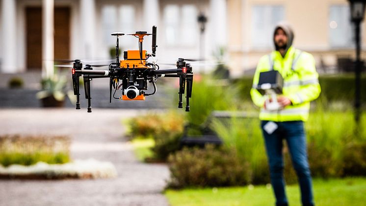 En drönare med autonoma egenskaper. I bakgrunden syns en säkerhetspilot redo att ta över kontrollen vid behov.