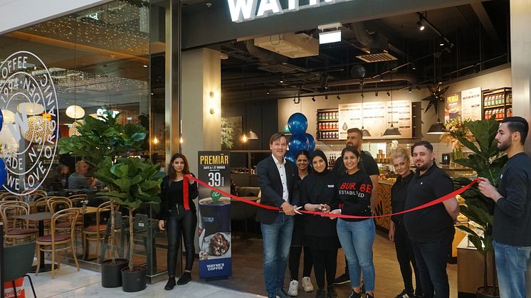 Mats Hörnell, VD Wayne's Coffee, klipper band vid premiären av Wayne's i Täby Centrum