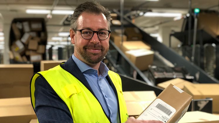 Pressesjef John Eckhoff i Posten Norge med en av 200.000 pakker som skal gjennom Logistikksenter Oslo i dag. FOTO: Posten