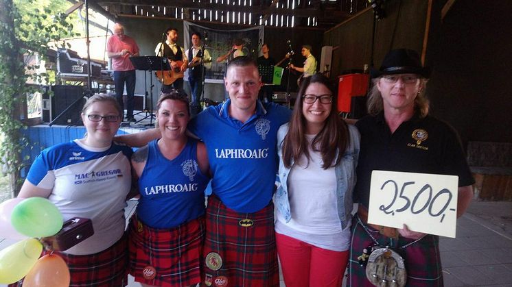 Cheforganisator Martin Kuhne, präsentiert stolz den Spendenscheck am Ende der Highland Games