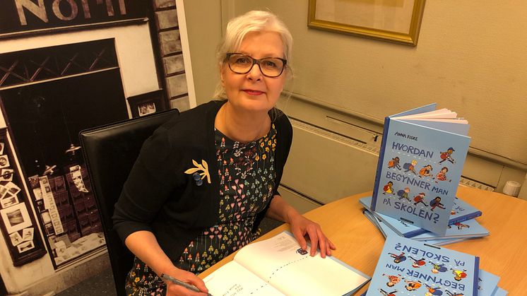 Bildebokskaper Anna Fiske signerer en bunke av sin ferske bok "Hvordan begynner man på skolen". Foto: Tanja Hoel