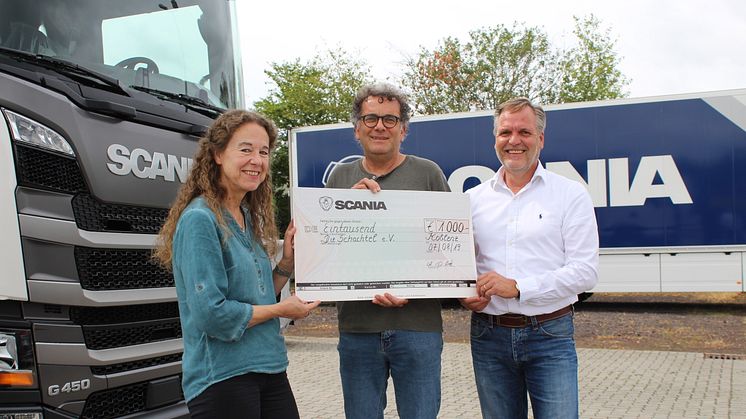 Andrea Gries (li.) und Detlev Both (r.), beide Betriebsrat Scania Deutschland, überreichen den Spendenscheck in Höhe von 1.000 Euro an Jürgen Michel (Mitte) vom Koblenzer Verein „Die Schachtel“.