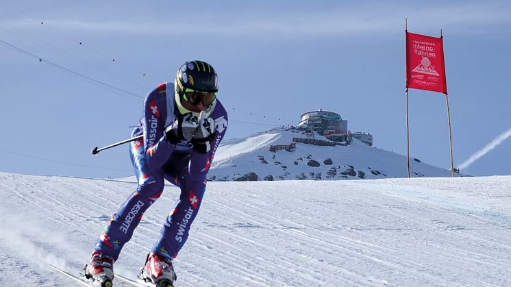 Rennfahrer bei der Inferno-Abfahrt mit dem Schilthorn-Gebäude im Hintergrund