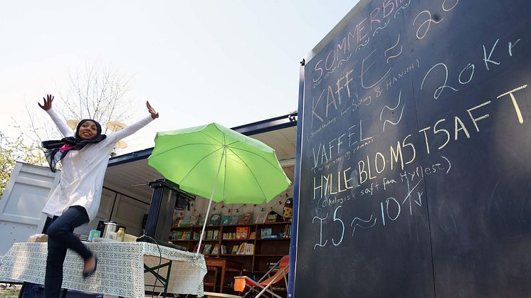 Amber er en av ungdommene som har fått sommerjobb i Deichman. Her selger hun kaffe og vafler på sommer-biblioteket på Schous plass.