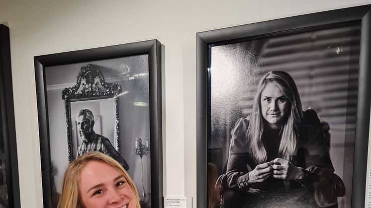 Birgit Skarstein foran sitt eget portrett i utstillingen "Best – Paralympisk gull"