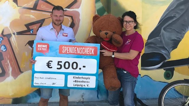Mirko Behling vom REWE-Markt übergibt 500 Euro an Kerstin Stadler von Bärenherz