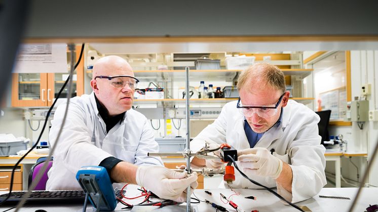 Edwin Jager vid Linköpings universitet (höger) och Nils-Krister Persson vid Högskolan i Borås (vänster) monterar en ”textil muskel” i en uppställning av mätinstrument som mäter kraft.