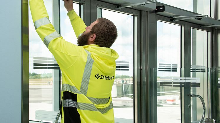 Tekniker från SafeTeam installerar dörrautomatik på dubbeldörr.