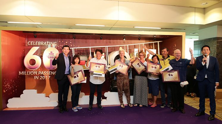 CAG’s Chief Executive Officer, Mr Lee Seow Hiang (first from left) and Scoot’s Chief Operating Officer, Mr Ng Chee Keong (third from right), with the six lucky passengers who joined Changi Airport’s 60 millionth passenger celebrations
