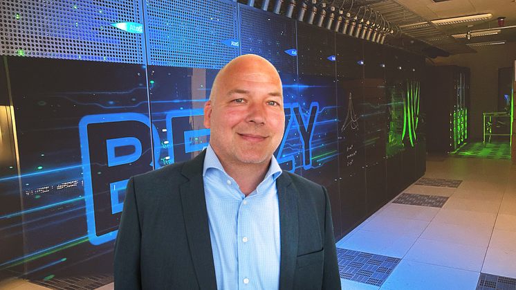 Roger Kvam i Sigma2 leder prosjektet som skal finne et egnet datasenter for Norges fremtidige HPC- og lagringsanlegg. Her foran Norges kraftigste superdatamaskin «Betzy». Foto: Sigma2.