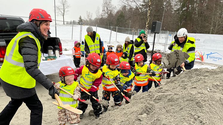 Kommunstyrelsens ordförande Caroline Dieker (M) tar ett första spadtag tillsammans med barn från Kristinagården.