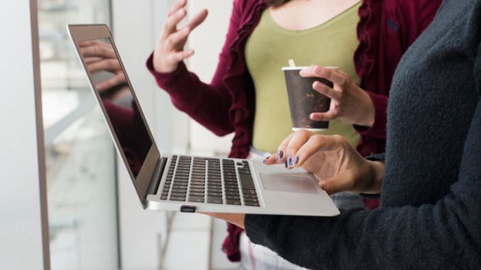 Två personer som för en dialog och antecknar på laptop. Man ser inte personernas ansikten, bara halvkropp. 