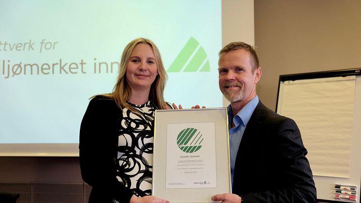Therese Fredriksson, hotellsjef på Scandic Grensen, mottar bevis på at hotellet har blitt sertifisert med Nordens offisielle miljømerke fra Tormod Lien, Svanemerket.  