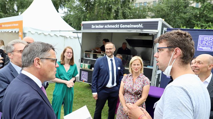 Tobias Berg vom Hofgut Richerode erläutert Ministerpräsident Boris Rhein (CDU) beim Hessenfest in Berlin das Konzept der Sozialen Landwirtschaft innerhalb Hephatas.