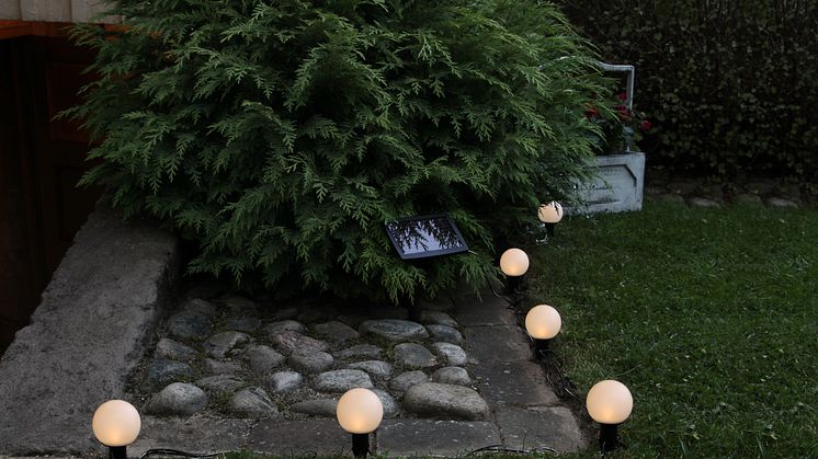 Solcellsladdad ljusslinga med vita bollar - ett fint och innovativt sätt att få det mysigt trädgården!