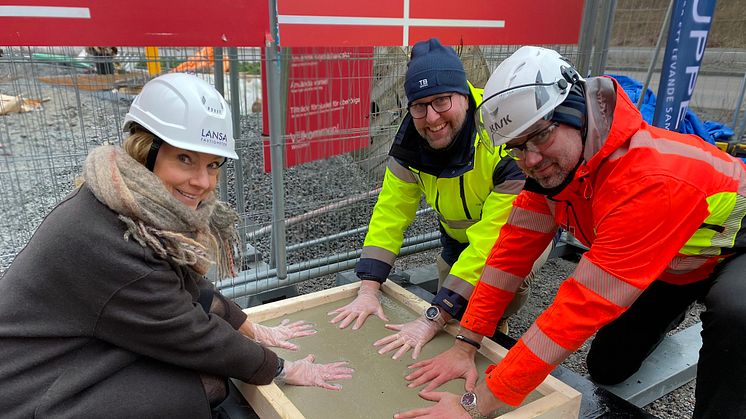 Ulrika von Wachenfeldt, projektchef på Lansa Fastigheter, Lars Kylin, vd TB-Gruppen Bostad, och Mattias Uppsäll, arbetschef på Veidekke genomför den symboliska första gjutningen. Foto: Anna Granander, Lansa Fastigheter