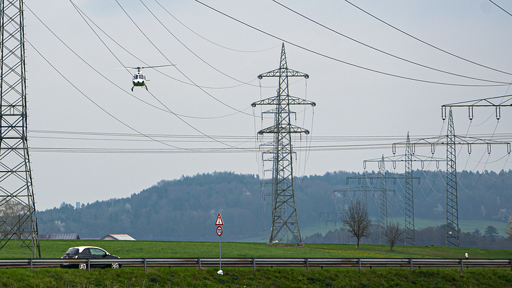 Der Heli schwebt nah an die Hochspannungsleitung heran, damit die Techniker des Bayernwerks die Masten und Seile genau unter die Lupe nehmen können.