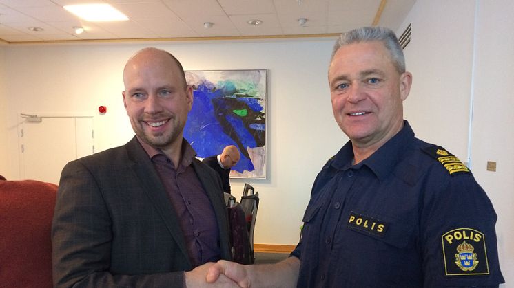 Hans Lindberg, kommunstyrelsens ordförande, skakar hand med Ronny Adolfsson, chef för lokalpolisområde Umeå.