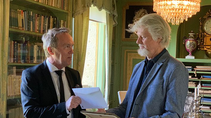 Författaren Lars Andersson tar emot Kulturpriset till Göran Tunströms minne av kultur- och näringslivschefen i Sunne, Per Branzén. Platsen är biblioteket på Mårbacka.