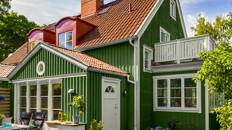 En fasad målad i grönt skapar harmoni och naturkänsla. Kulören heter Granbarr 091. Fönster och detaljer är målade med Regn 088.