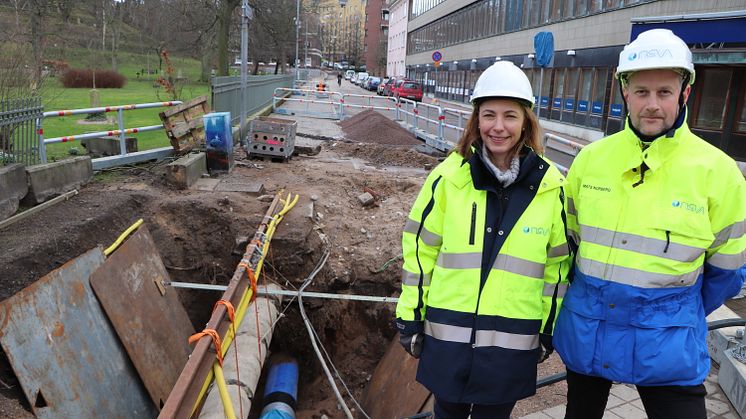 Mats Norberg och projektledare Eva Miltorp vid en grop där man ser hur den gamla ledningen infordrats med formpressad pe-lednining (blå). Metoden innebär att hela gatan i bakgrunden inte behövt grävas upp och där trafiken har kunnat rulla på. 