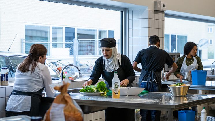 Kursister på flygtningeforløbet er i gang med at forberede mad til deres afslutningsmiddag.