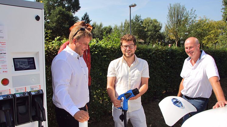 Bürgermeister Gerald Brehm (r.) und Thomas Oppelt (M.) vom Stadtmarketing nehmen gemeinsam mit Bayernwerk-Kommunalbetreuer Ralf Schwarz (l.) die neue Schnelladesäule am Parkplatz „Engelgarten“ in Höchstadt an der Aisch in Betrieb.