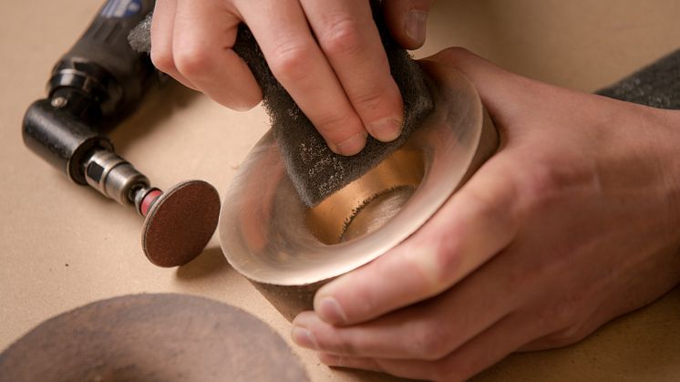 A tea light candle holder is carefully polished