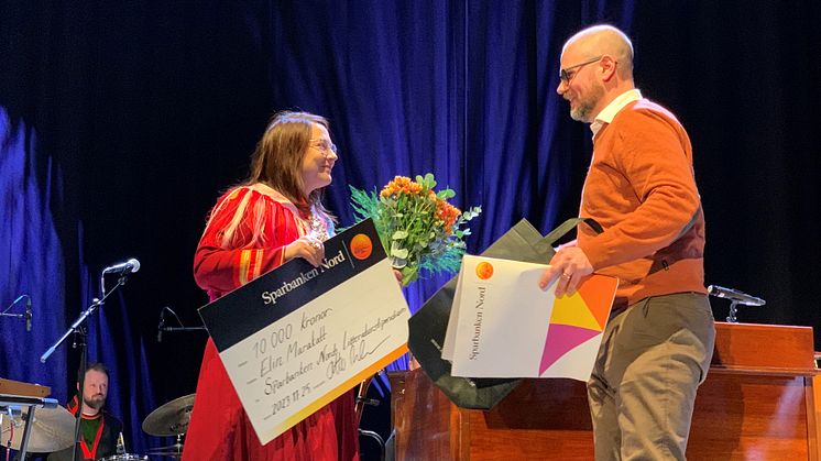 Elin Marakatt tar emot årets litteraturstipendium av Otto ANdersson, kontorschef Sparbanken Nord i Kiruna.