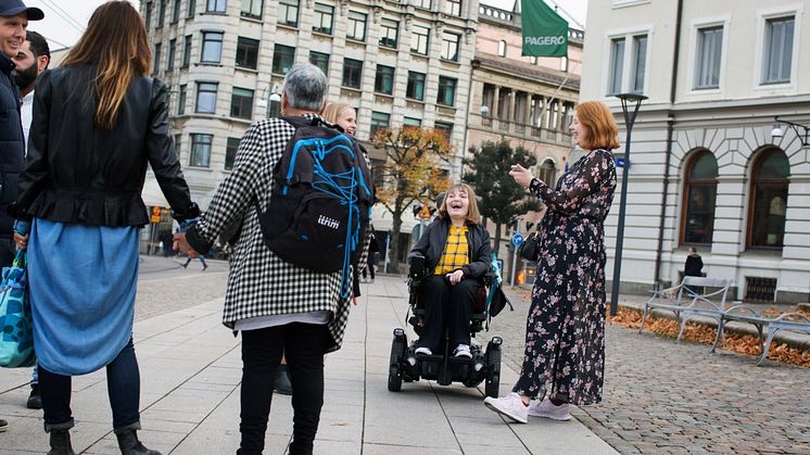 Ett gäng unga ser ut att ha träffats på en trottoar och stött på bekanta som stannat till för att prata.