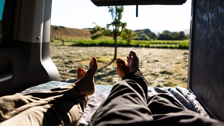 Eiderstedt: Camper liegen im Van und blicken in die Landschaft, Copyright: Lucas Wahl/ Julius Schrank