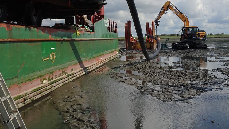 Bagger führt Schutzrohr zur Bohrung: Bei Niedrigwasser führt der Bagger das Schutzrohr zum Bohrkopf.