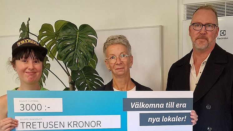 Vid invigningen tog Viola Juric, enhetschef för Slättbergsvägen 180 och Johanna Johansson, en av de boende, emot ett presentkort i stort format från Hans-Åke Erlandsson, Eidars projektledare för renoveringen och anpassningen av lokalerna.